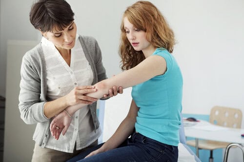 Dermatologist examining a patient's arm