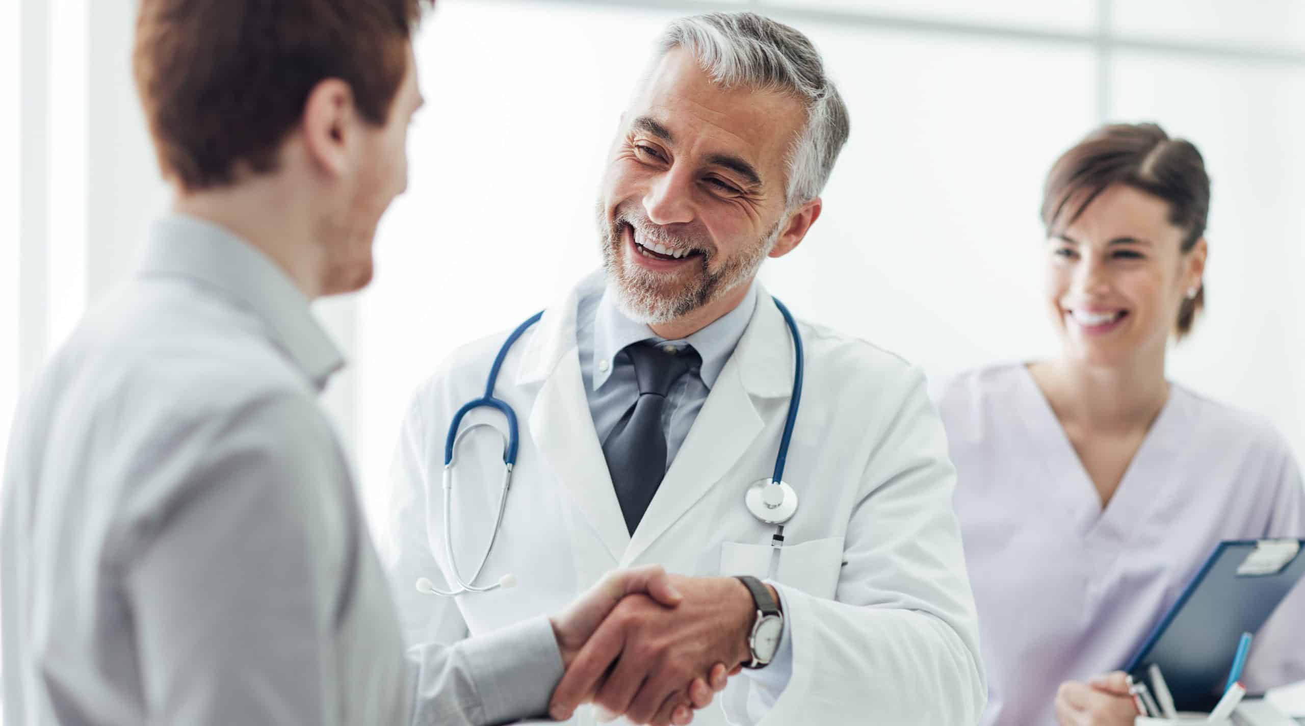 Smiling doctor giving patient a handshake