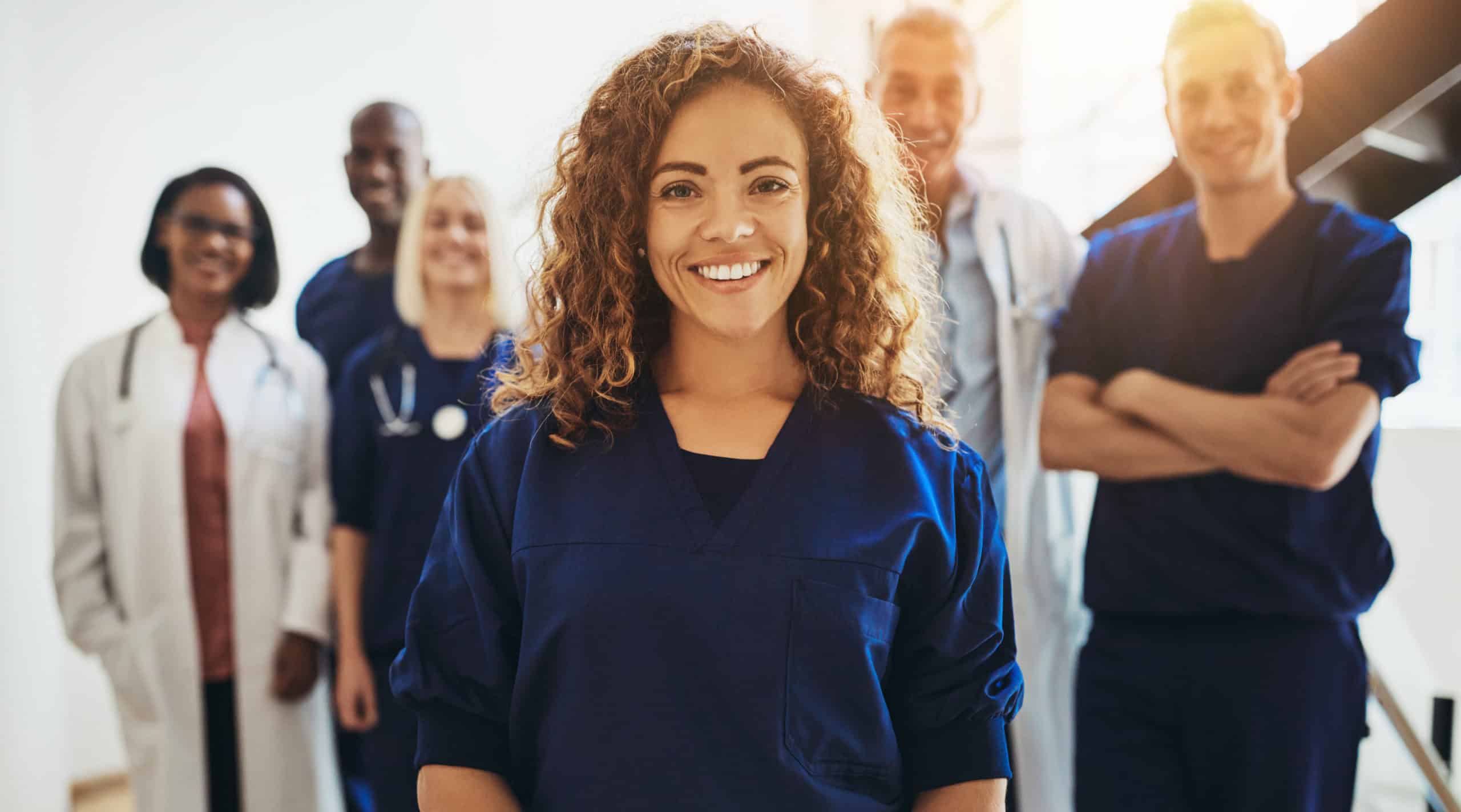 Smiling female doctor standing with medical colleagues