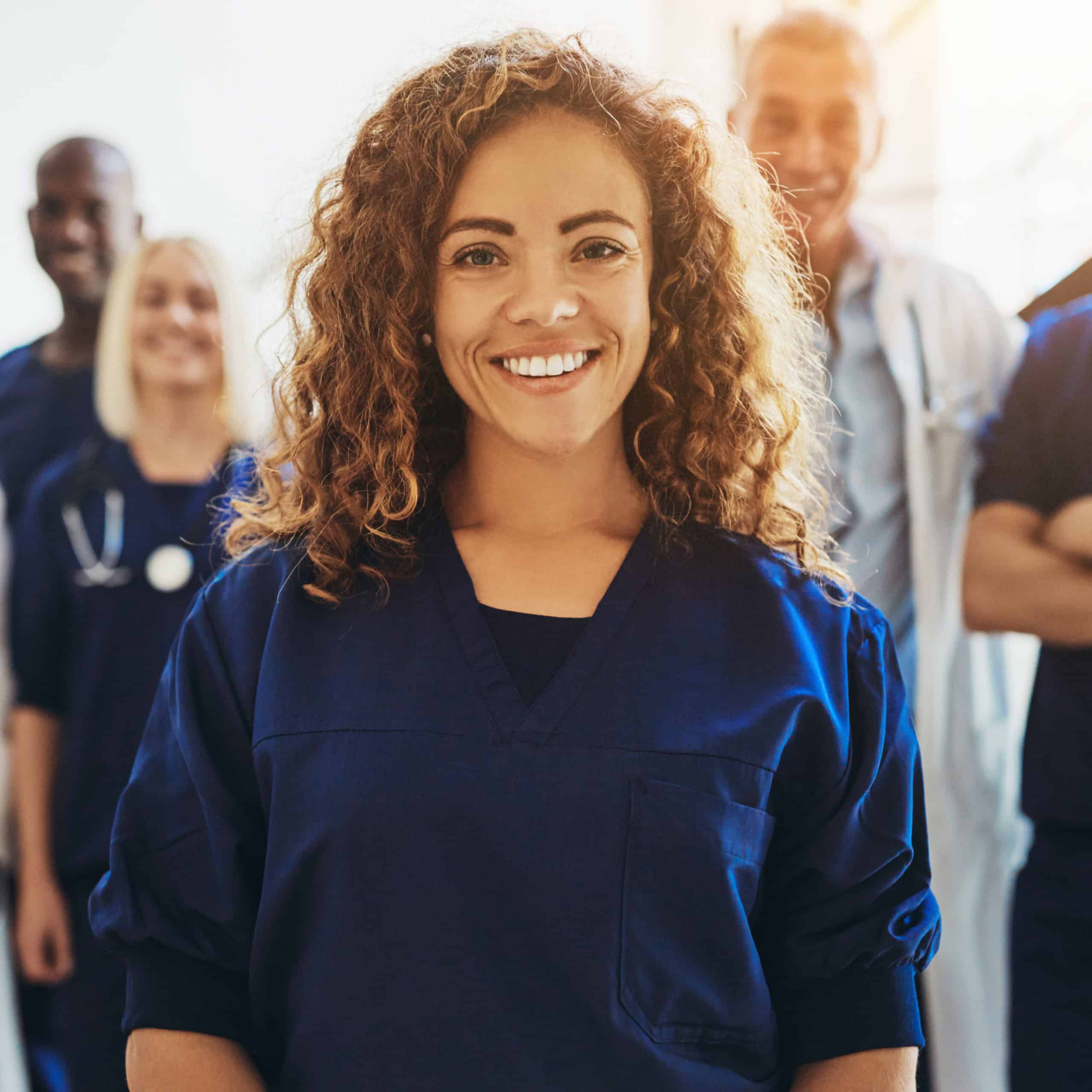 Smiling female doctor standing with medical colleagues