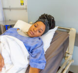 Young female patient in hospital bed.