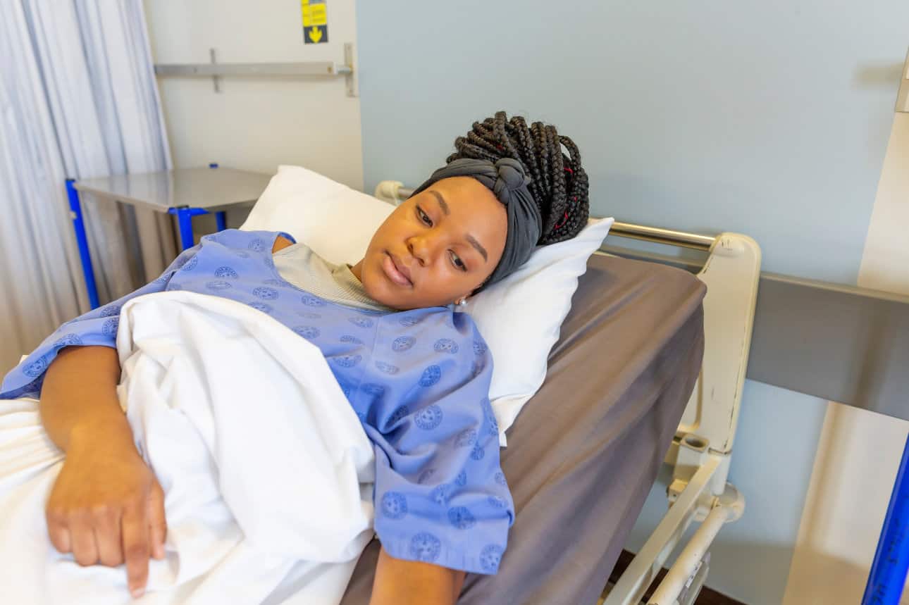 Young female patient in hospital bed.